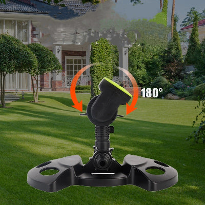 Arroseur oscillant sur pelouse devant maison
