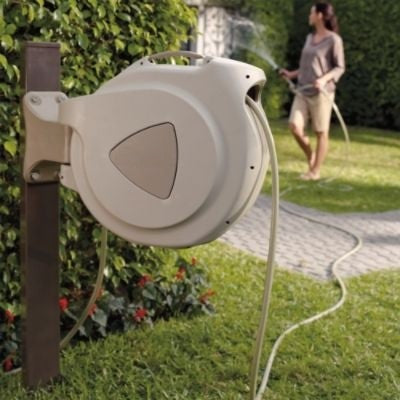 dame arrose jardin avec enrouleur tuyau retractable beige