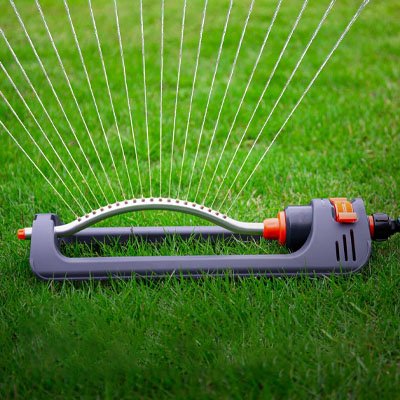 Pelouse verte irriguée avec arroseur oscillant