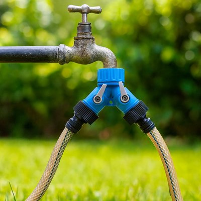 Raccord tuyau arrosage bleu vissé robinet dans jardin