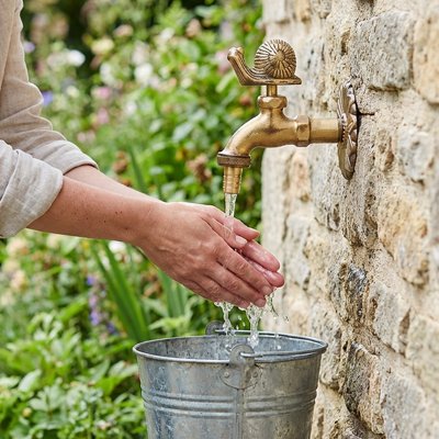 Dame se nettoie les mains au Robinet de jardin 