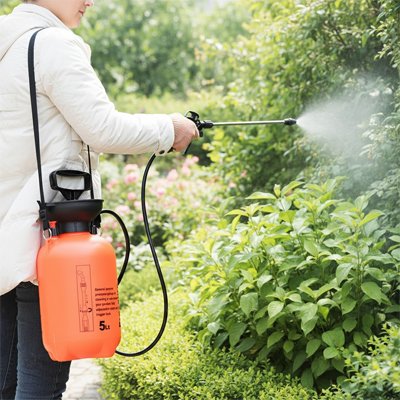 Monsieur  avec pulvérisateur à main  orange arrose plantes