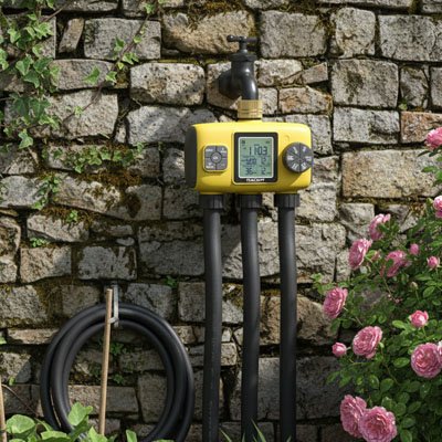 Programmateur arrosage 3 voies installé contre  mur en pierre