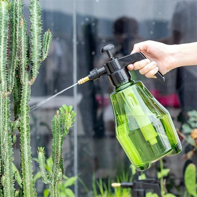 Pulverisateur vert avec jet direct sur plante