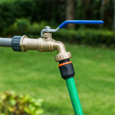 Robinet de jardin avec tuyau vert raccordé