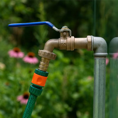 Robinet de jardin bleu avec tuyau connecté